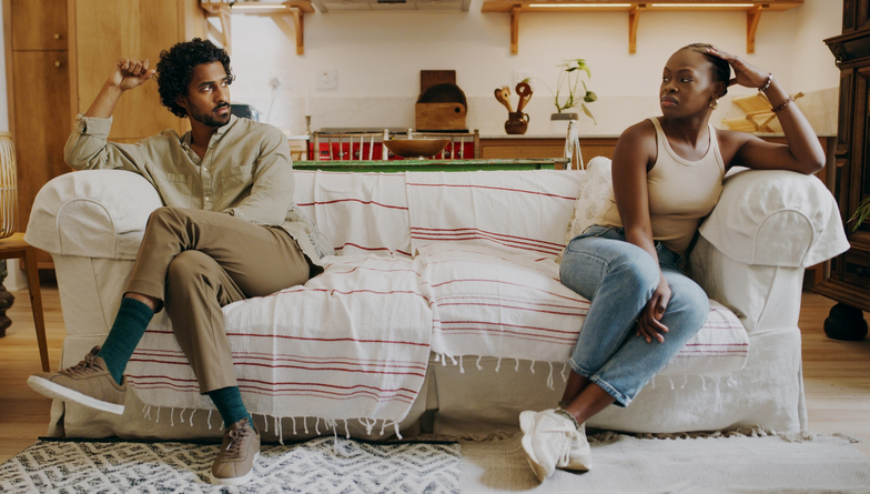 Full length shot of a young couple sitting on the sofa together and ignoring each other after an argument