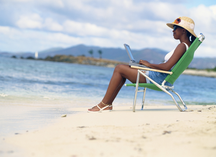 Woman Using a Laptop on the Beach