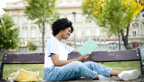 African American student reading in the park