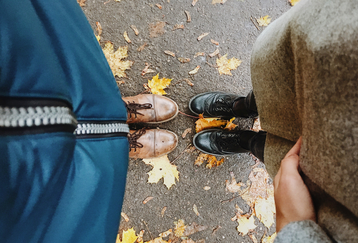Low Section Of Man And Woman Standing By Autumn Leaves