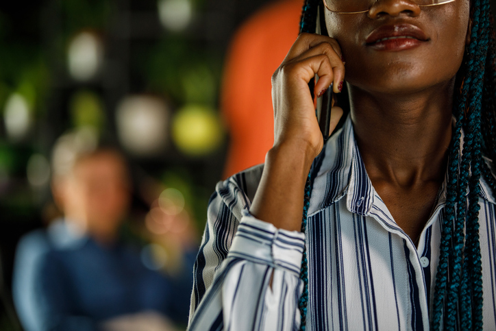 Copy space shot of Black businesswoman with blue braids talking on the phone