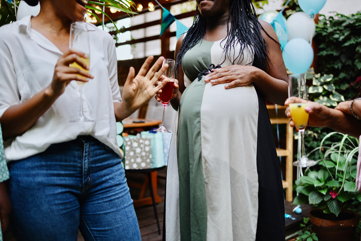 Unrecognisable female friends celebrating at baby shower