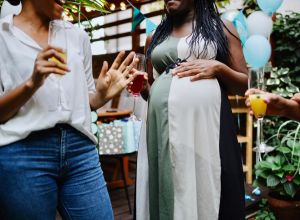Unrecognisable female friends celebrating at baby shower