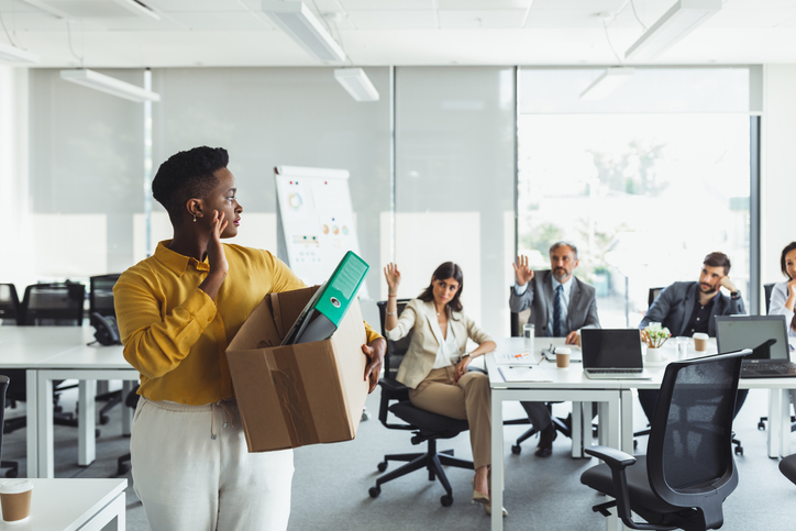 Black Young Woman office worker is unhappy with being fired from a company packing things into cardboard boxes.