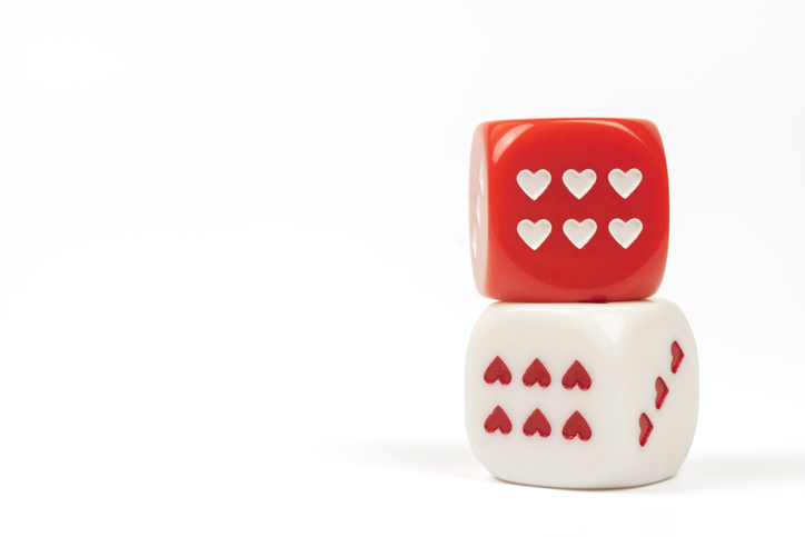 Two game dice with heart shaped on white background.