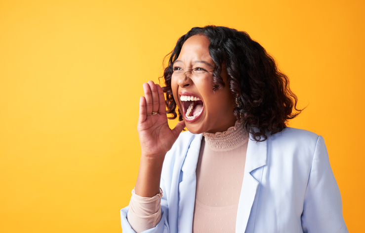 Portrait of isolated excited woman screaming or yelling in expressing voice protest. Female shouting with hand gesture looking at a deal with copy space for advertising and marketing.