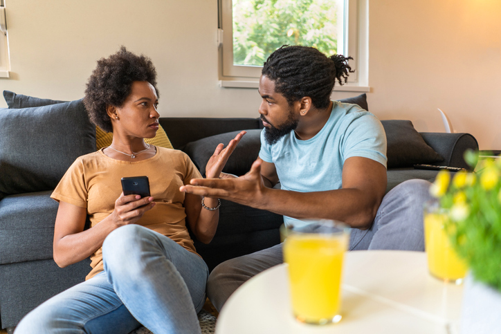Pareja afroamericana discute en casa sobre la infidelidad