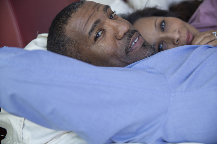 Portrait couple relaxing, laying in bed