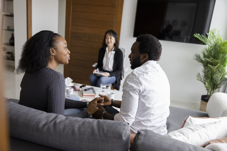 Marriage counselor listening to couple talking during session