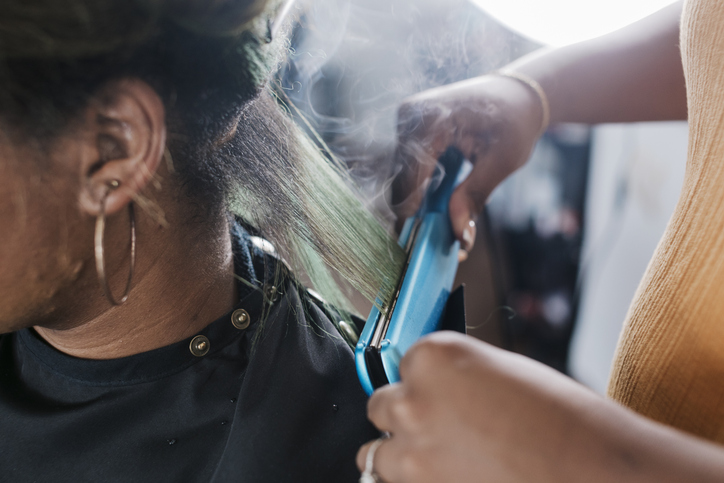Close Up Of Black Hairdresser Straightening Client's Hair