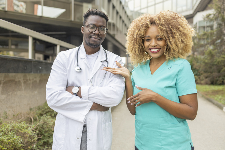 Smiling nurse pointing to a handsome doctor