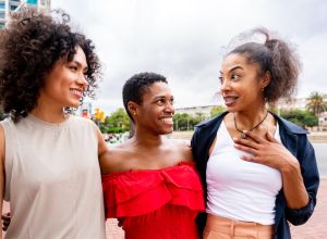 Three mixed race hispanic and black women bonding outdoors exchanging gossip