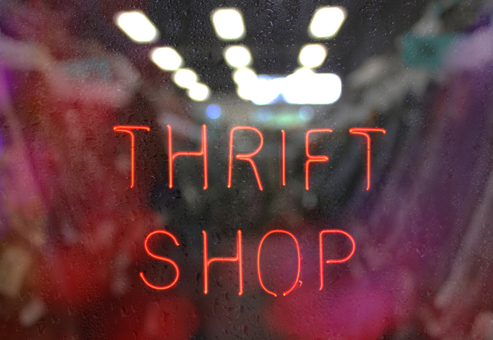 Vintage neon thrift shop sign in wet window