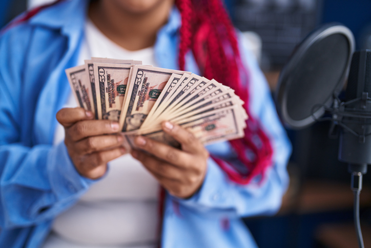 African american woman artist counting dollars at music studio