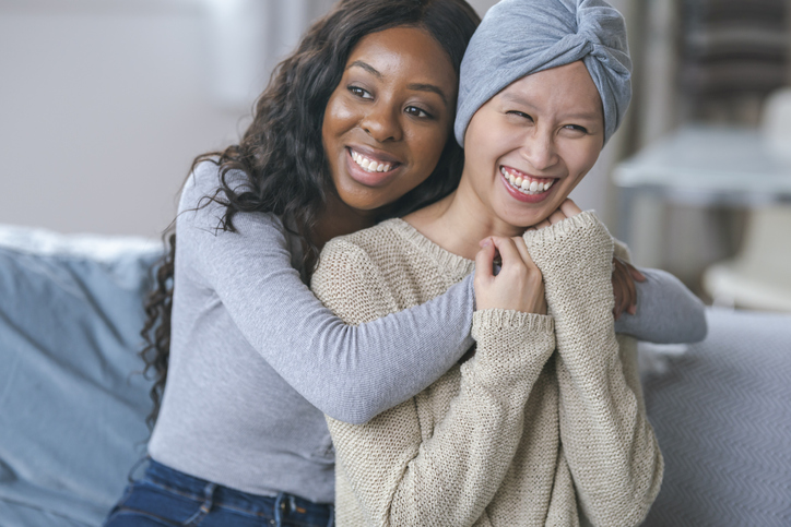Courageous woman with cancer embracing best friend