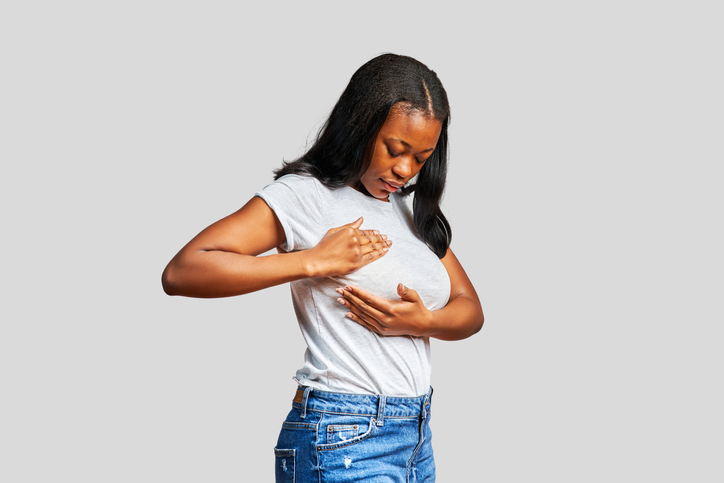African woman touching her breast in a cancer detection examination