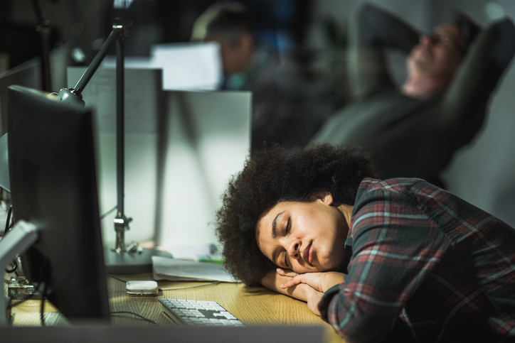 Tired African American programmer taking a nap in the office.