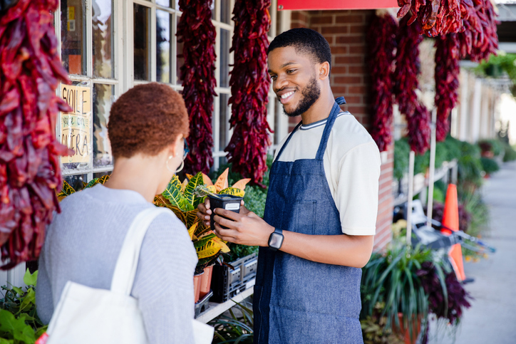 Male flower shop employee talks to the customer