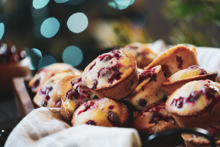Cranberry muffins in a wooden tray with Christmas tree bokeh