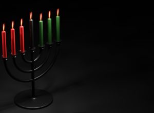 Kwanzaa Festival of unity and togetherness. Seven candles on menorah candleholder. Black Christmas celebrations. 3d illustration banner on black background.