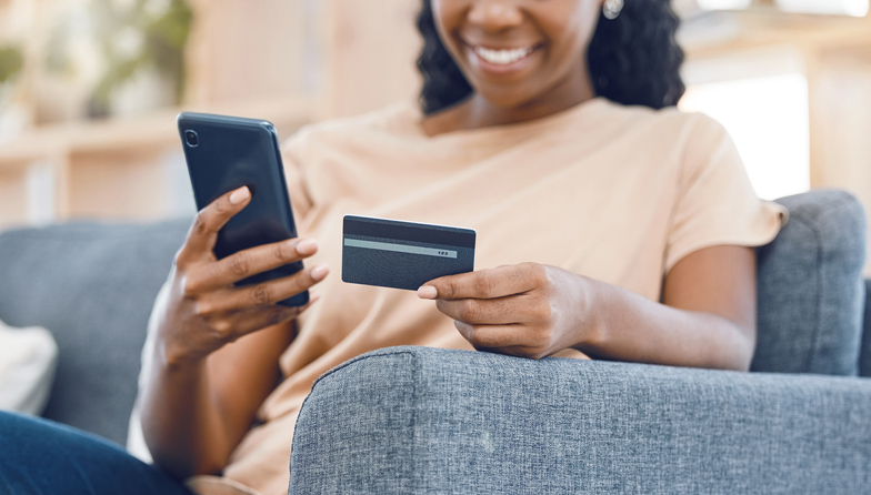Black woman, online shopping and ecommerce phone payment on credit card, mobile money and internet finance on home sofa. Closeup of happy african person, cellphone banking and easy fintech technology