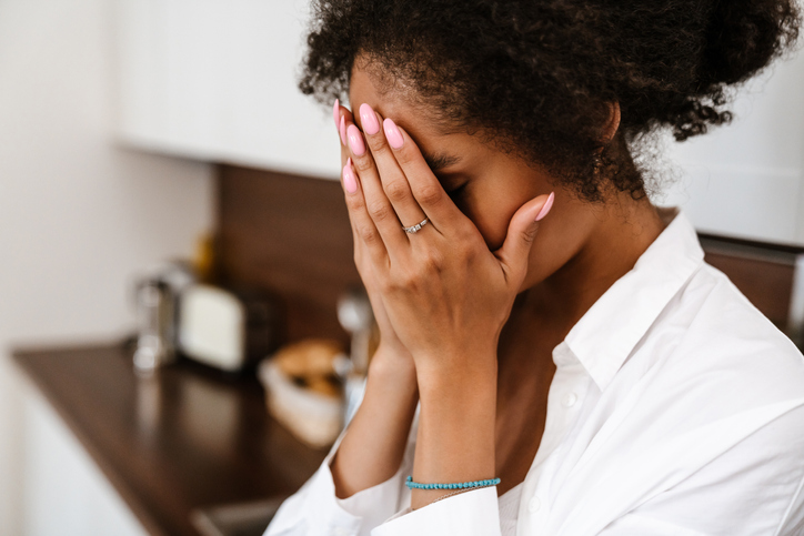 Young black woman being upset and thinking about abortion at home