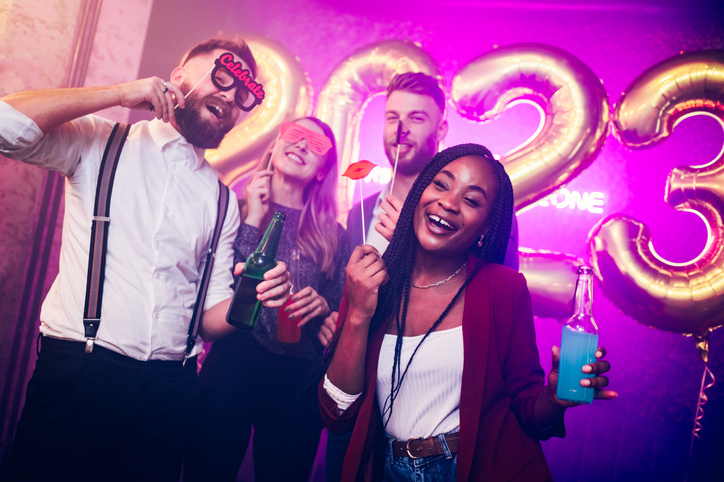 Multiracial friends celebrating new years eve with party props in the club and making New Year's resolutions