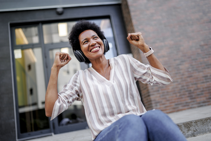 African American woman on vacation dancing and enjoying music outdoors