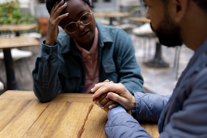 Man holding girlfriends hand, supporting her