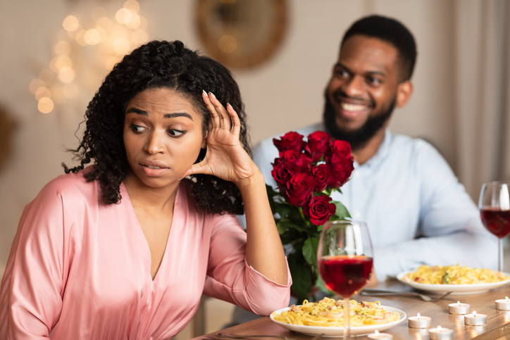 Black Woman On Unsuccessful Date In Restaurant wondering how to cut a date short