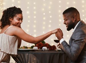 Charming black guy kissing his girlfriend hand during dinner