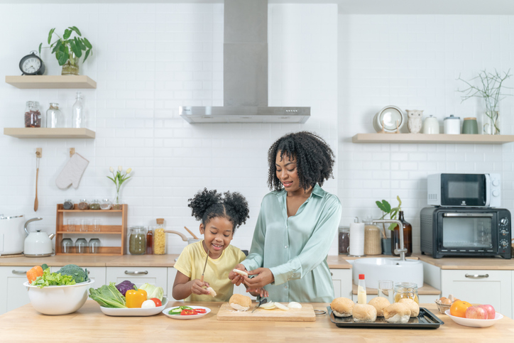 Daughter and mother cooking together at kitchen