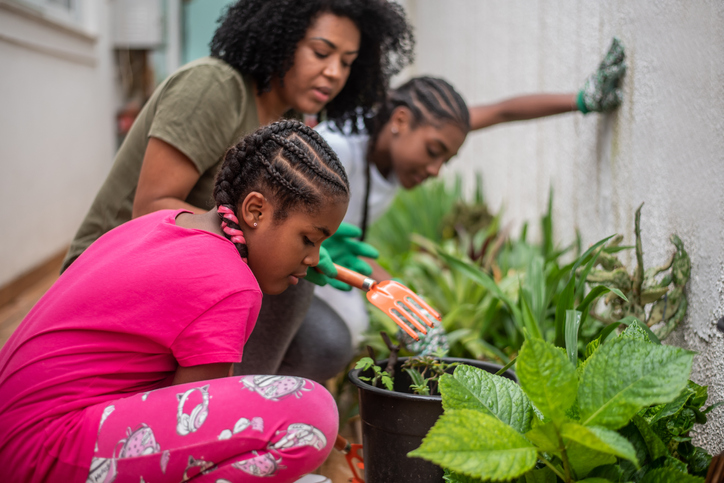 Mother and daughters tending the garden at home