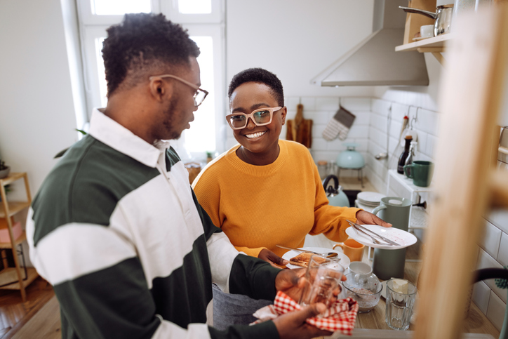 Young couple enjoying washing dishes together