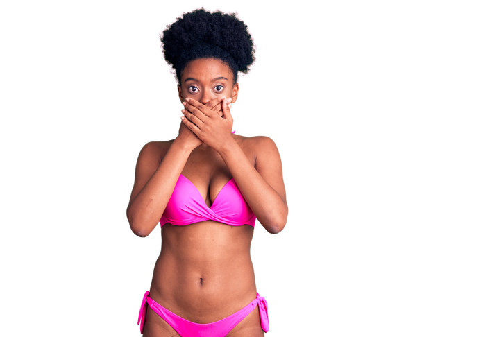 Young african american woman wearing bikini shocked covering mouth with hands for mistake. secret concept.