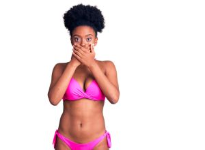 Young african american woman wearing bikini shocked covering mouth with hands for mistake. secret concept.