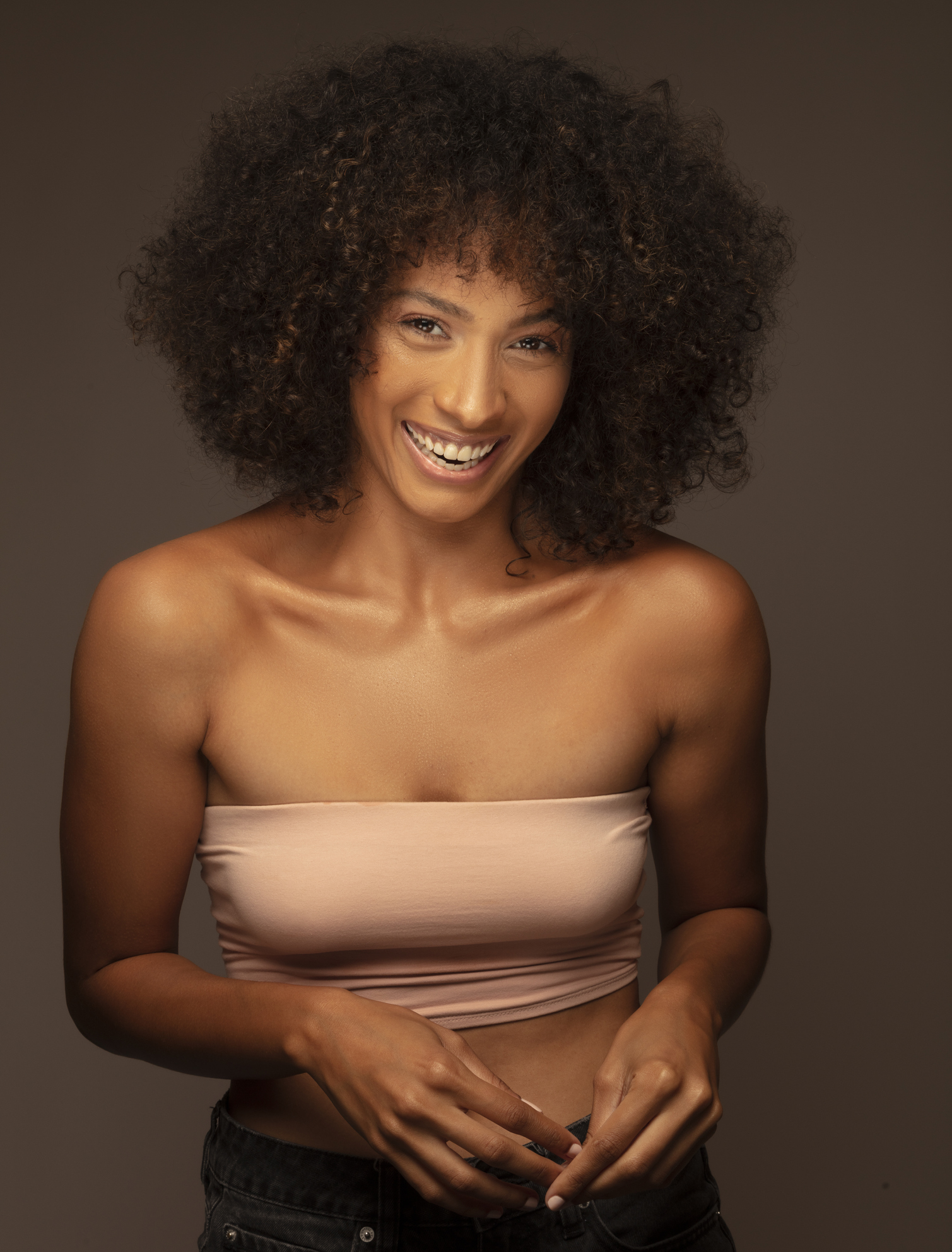 Portrait of beautiful brunette woman with smiling curly hair.