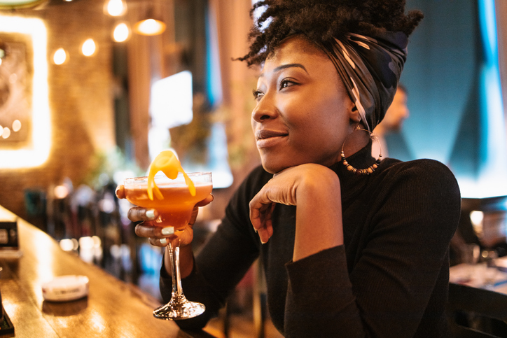 African woman drinking cocktail enjoying her vices