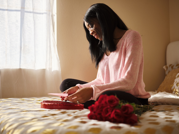 african american woman opening love letter on valentines day and valentine's day gift