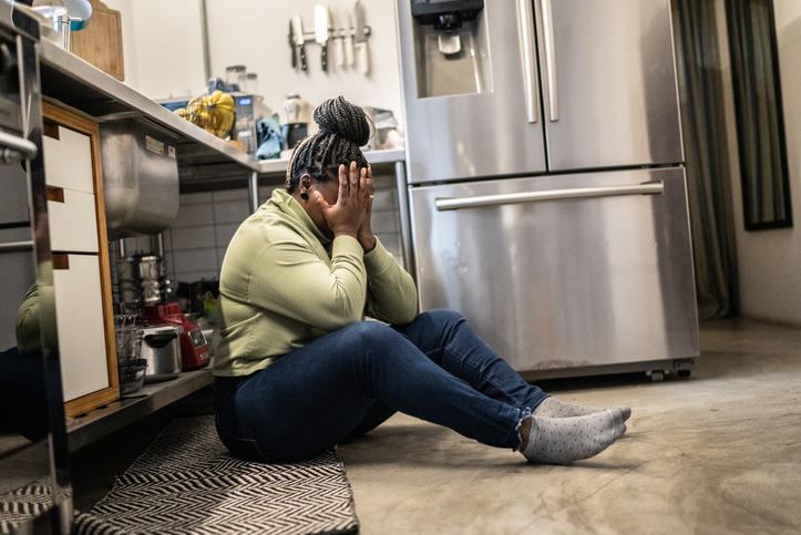 Sad mid adult woman in the kitchen at home