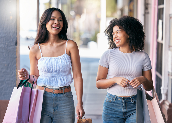 Friends, shopping and walking together while happy, talking and laughing outdoor at city mall while excited about sale, deal and promotion for savings. Women in Milan for retail customer experiene