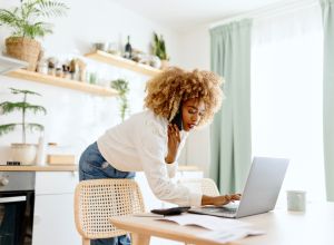 Beautiful woman typing on a laptop buying a house