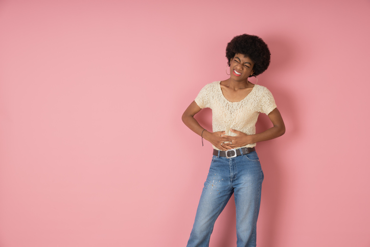 Young black woman suffering with severe stomach pain