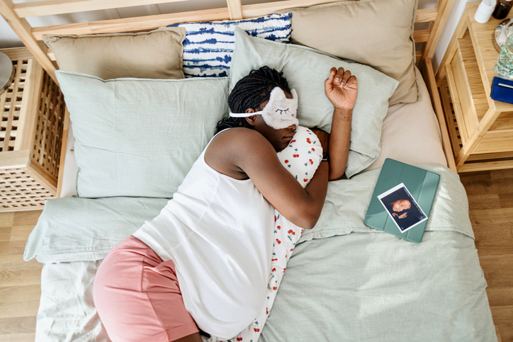 Pregnant woman sleeping in her bed