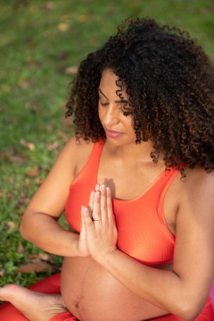 pregnant black woman doing yoga outdoors