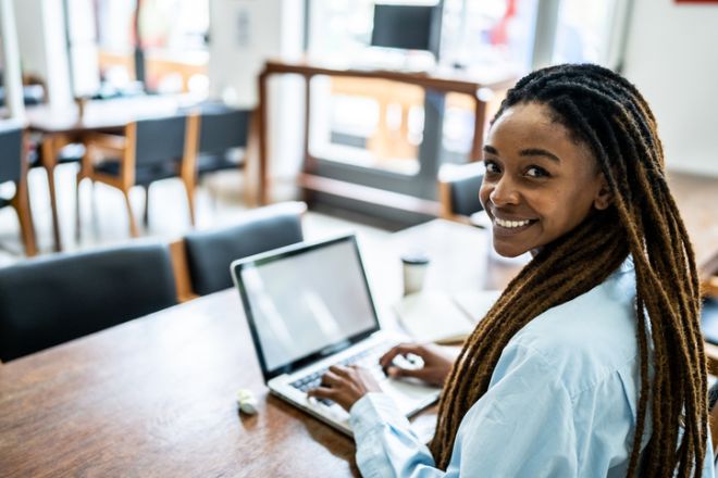 Portrait of a young woman using the laptop in the library