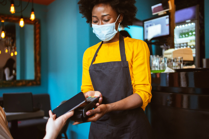 Young African-American woman works as a waitress in a Coffee shop dealing with new tipping culture