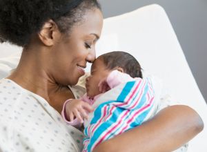 Mother with newborn at hospital room after receiving support from a doula and midwife