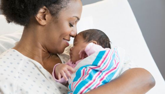 Mother with newborn at hospital room after receiving support from a doula and midwife