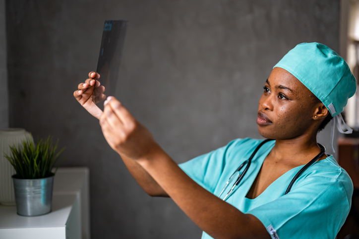 Black doctor in maternity ward reviewing test results